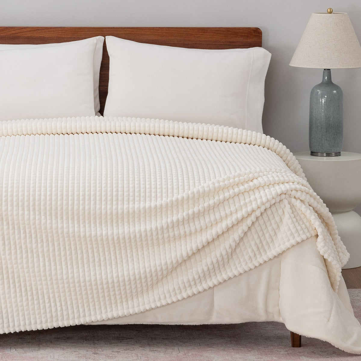 Image of a bed styled with a white waffle blanket