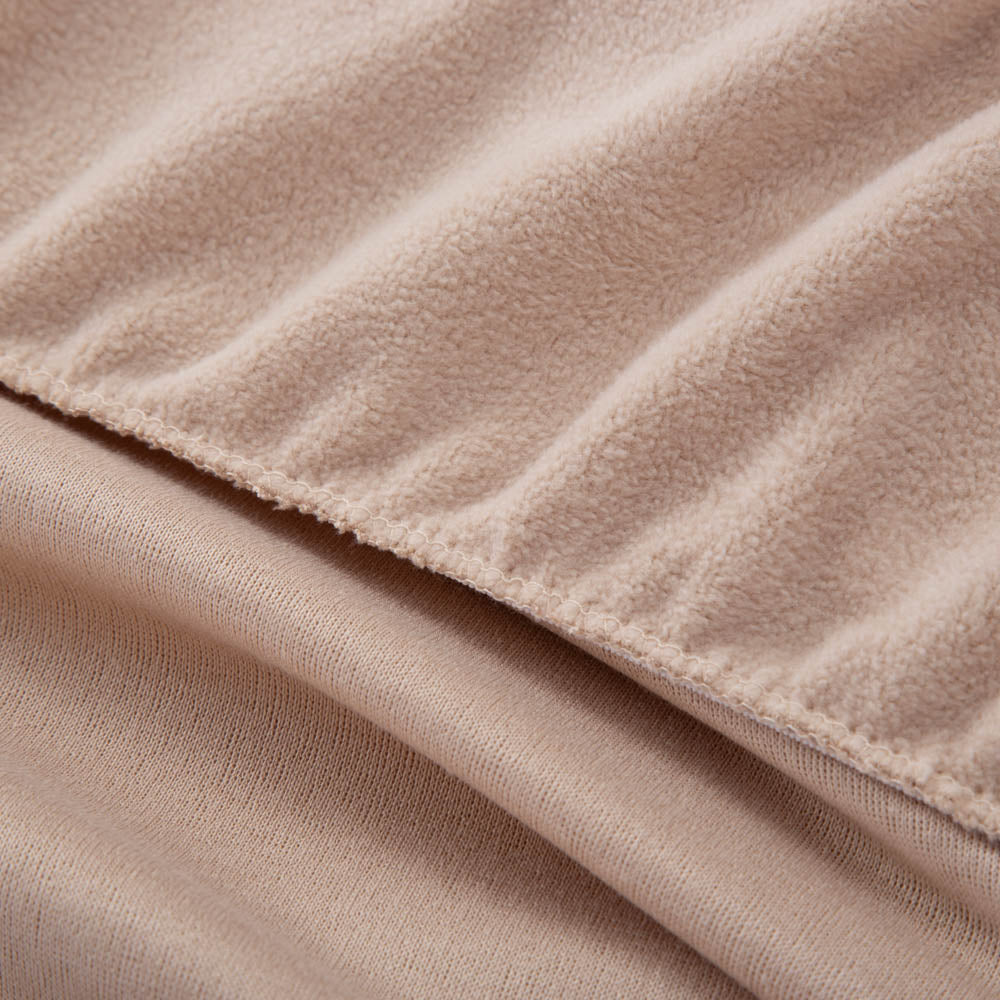 A close-up of a fitted beige sheet, highlighting the fabric texture.