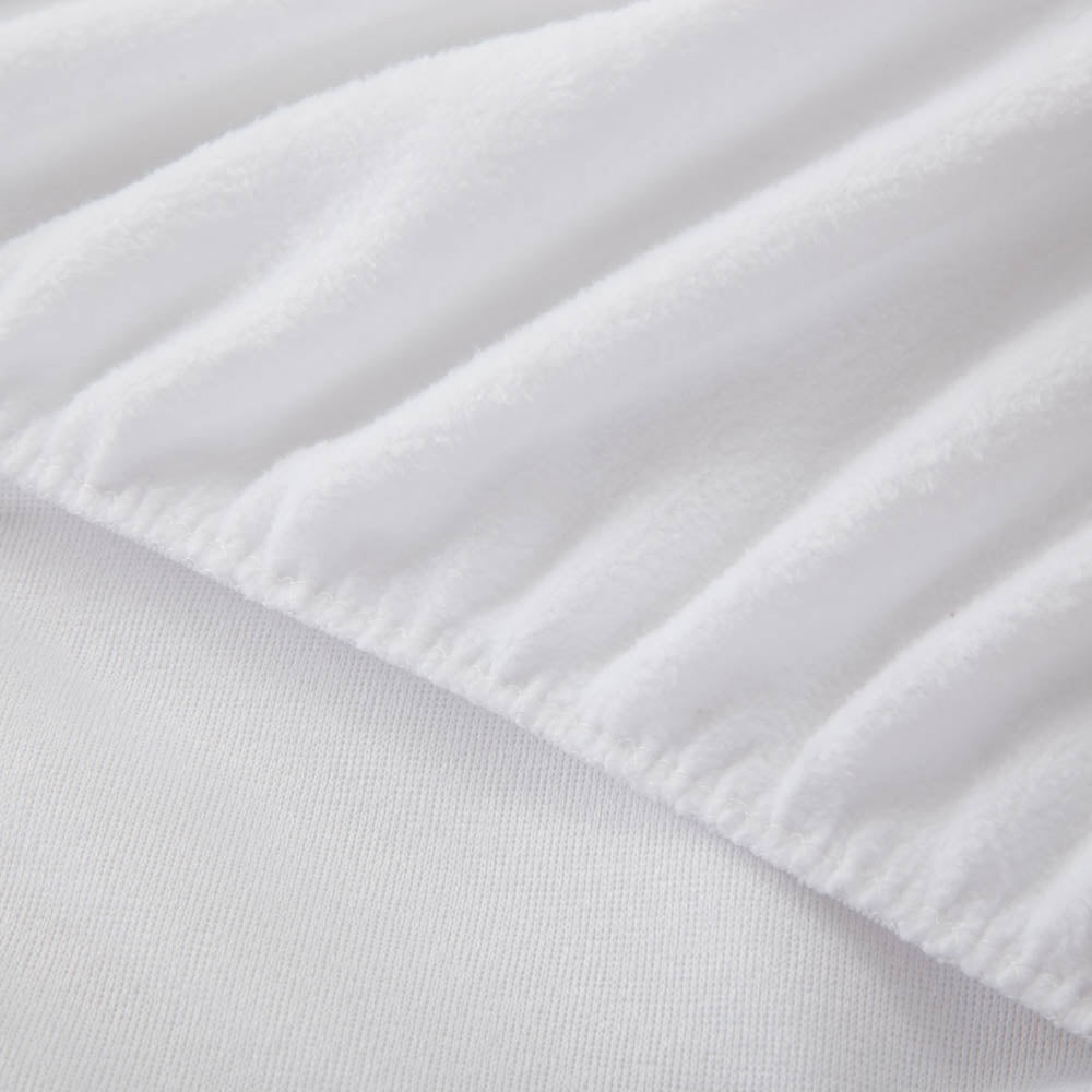 A close-up of a fitted white sheet, highlighting the fabric texture.
