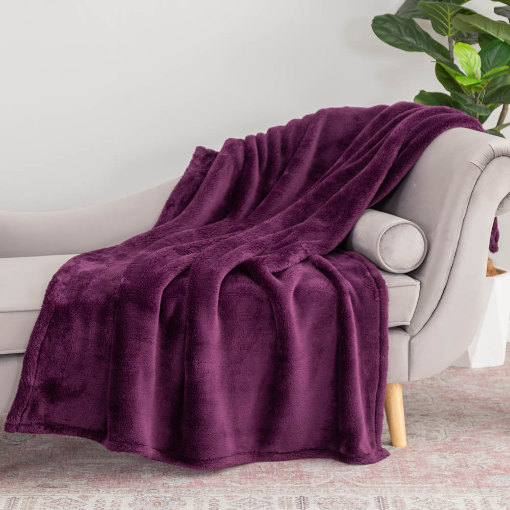 Purple extra fluffy throw draped neatly over a grey chair.
