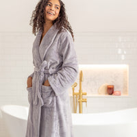 Woman wearing a lilac robe in a bathroom setting