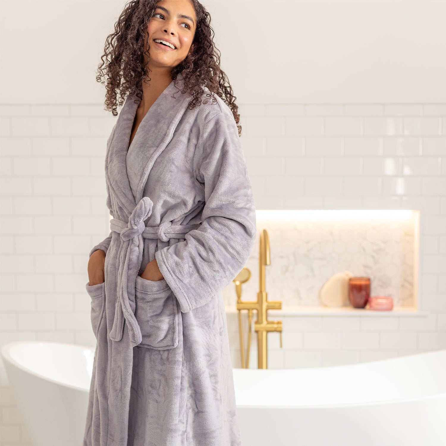 Woman wearing a lilac robe in a bathroom setting
