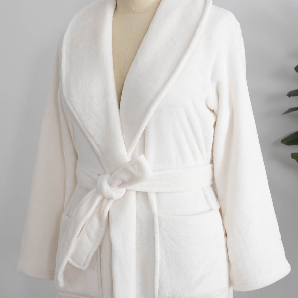 A white VelvetLoft Robe on a mannequin, displayed next to decorative items.
