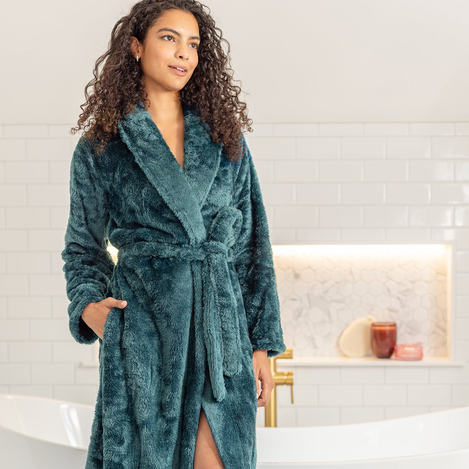 Woman wearing a teal robe in a bathroom setting