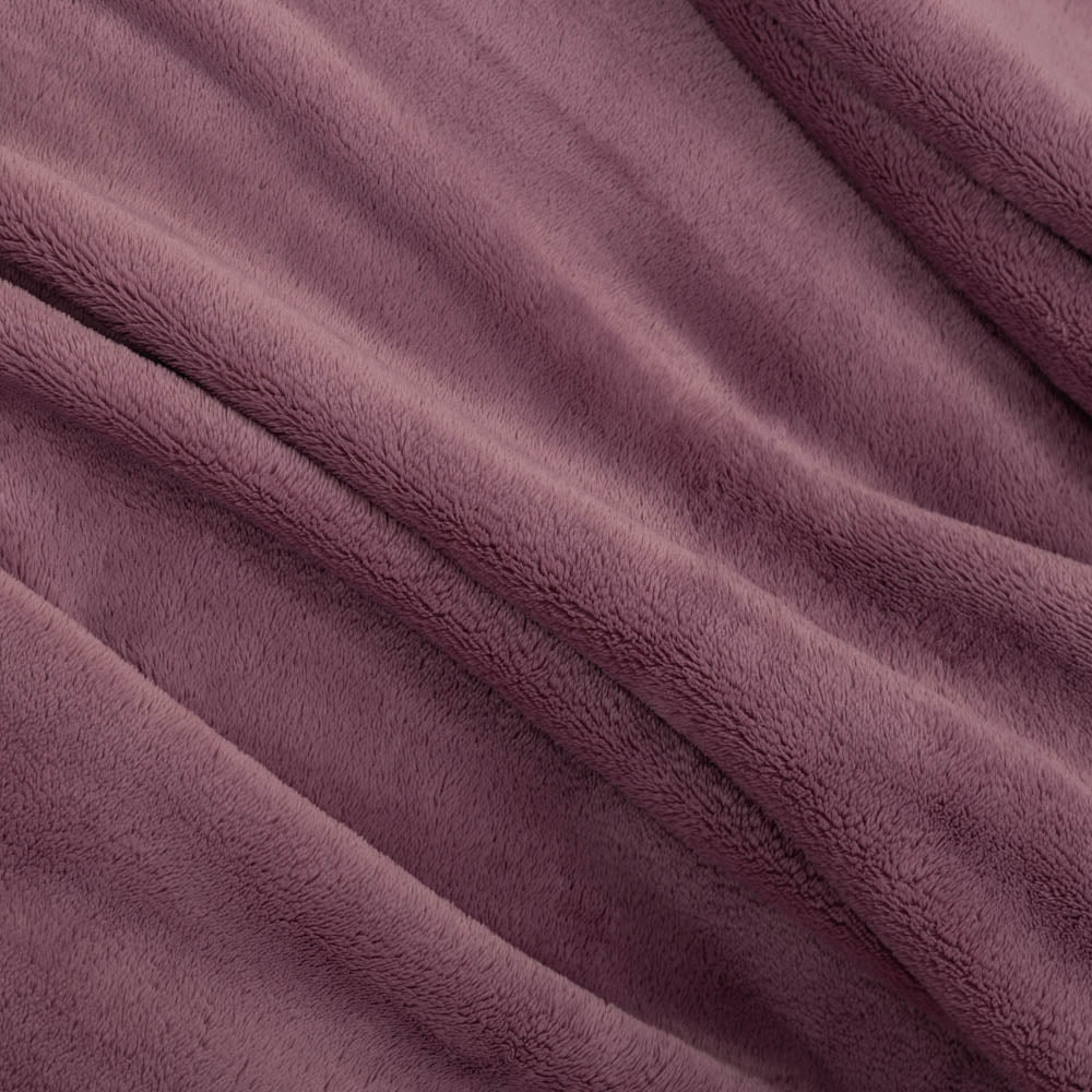 Close up of a purple PrimaLush throw, isplaying its smooth and plush texture.