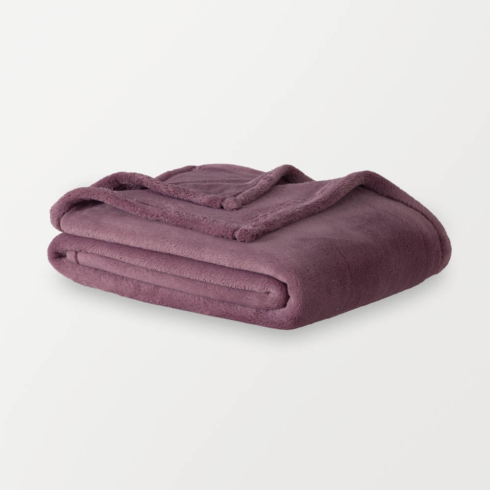 A purple PrimaLush throw folded neatly on a white surface.