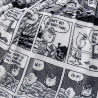 Close up of a black and white printed comic peanuts throw displaying the plush texture.
