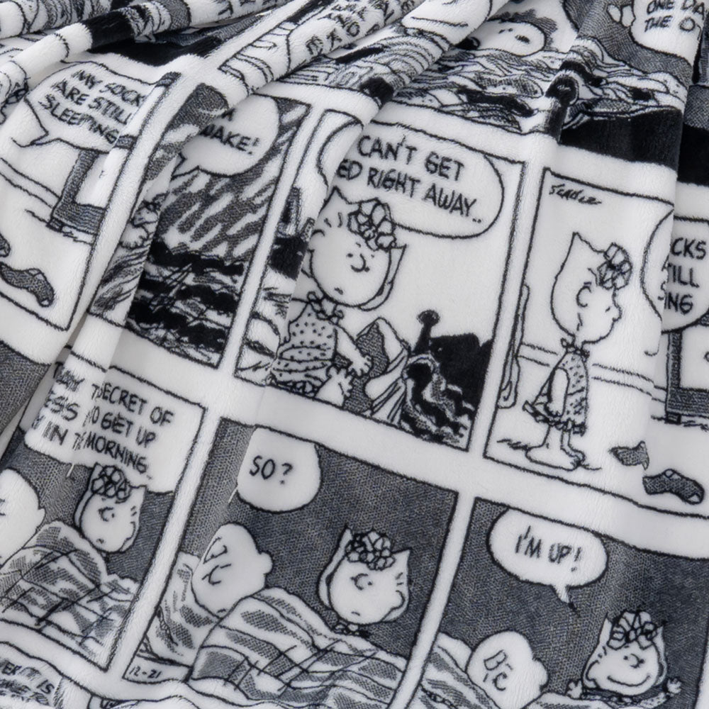 Close up of a black and white printed comic peanuts throw displaying the plush texture.