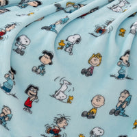 Close up of a blue peanuts gang throw displaying its plush texture.