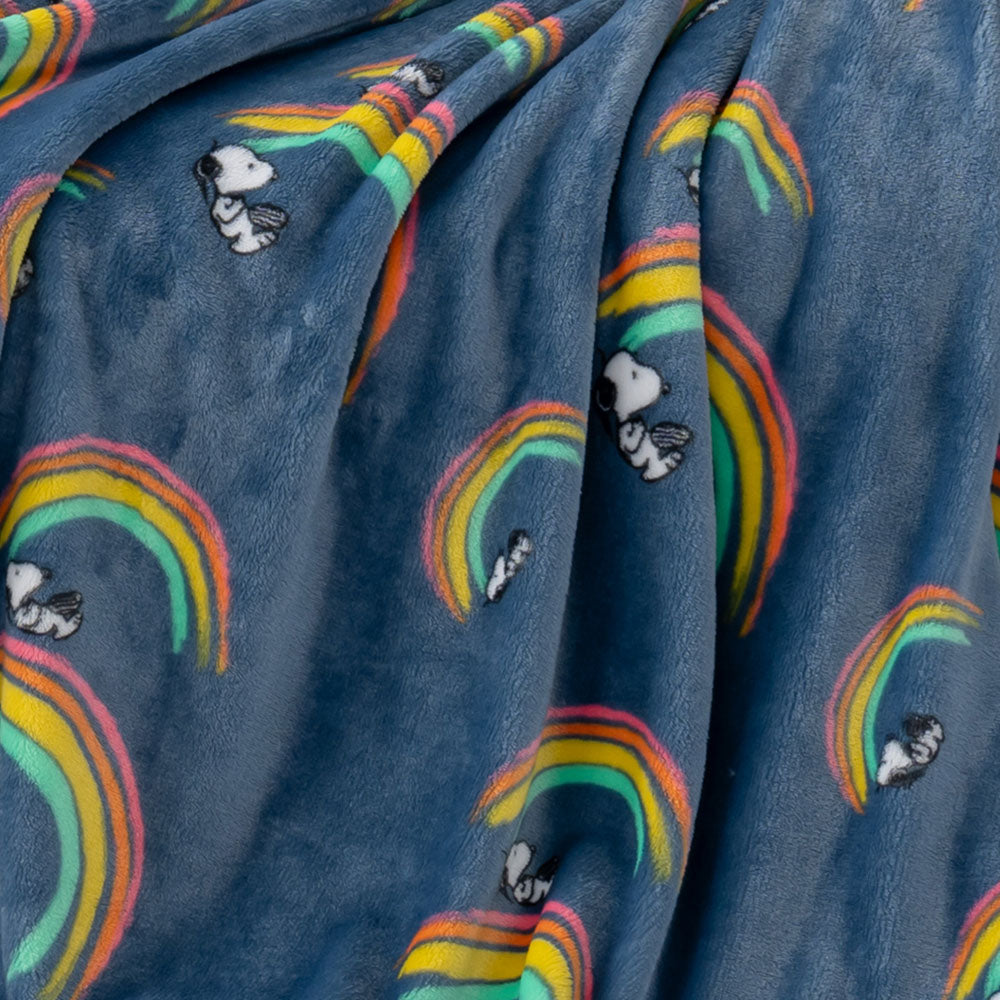 A close up of a blue rainbow snoopy throw displaying its plush texture.