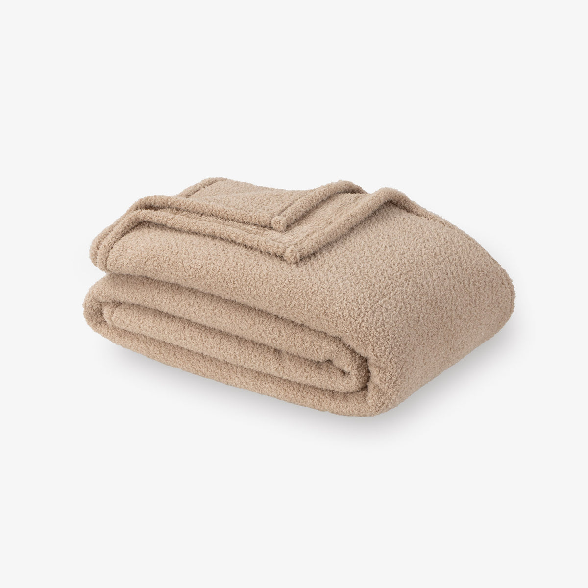 Folded beige blanket on a white background