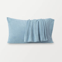 Blue pillowcases displayed on a white surface.