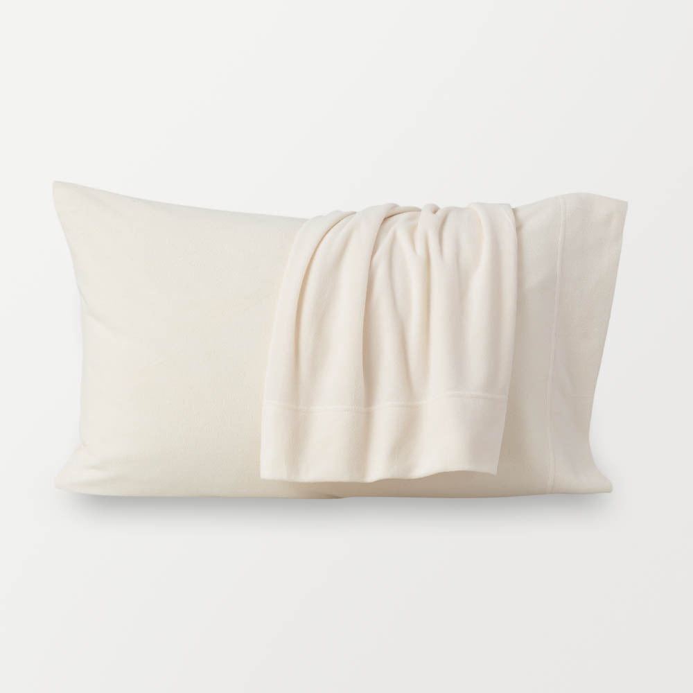 Warm ivory pillowcases displayed on a white surface.