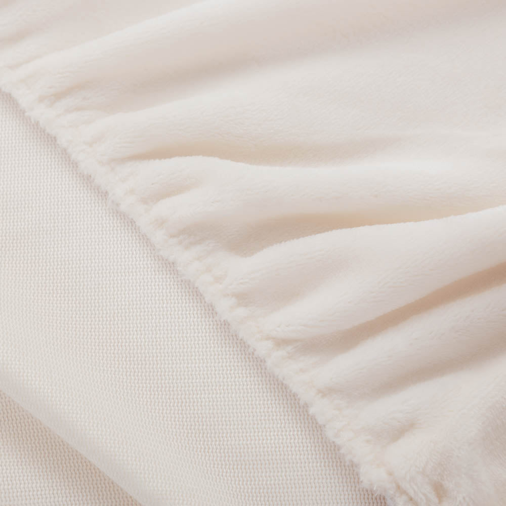 Close-up of Cream fitted sheet corner with plush texture.