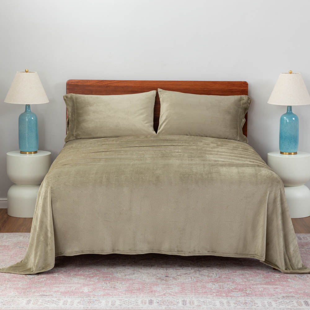 Dry Sage color plush sheet set on a large bed with two lamps on either side.
