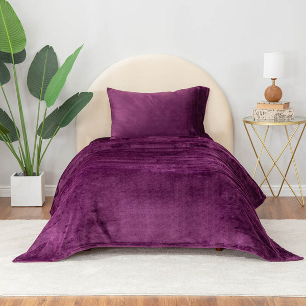 Eggplant sheet set styled on a bed.