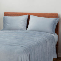 Polar Blue sheet set styled with two pillows on a bed.