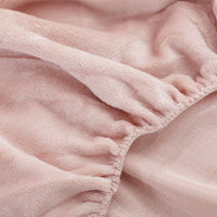 Close-up of a rose smoke fitted sheet corner.