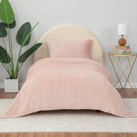Rose Smoke (blush color) sheet set on a bed with a nightstand and plant nearby.