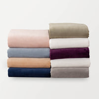 Folded stack of shrrt sets in variety of colors: rose smoke, polar blue, aruba sand, dress blue, dry sage, cream, eggplant, white, wild dove.
