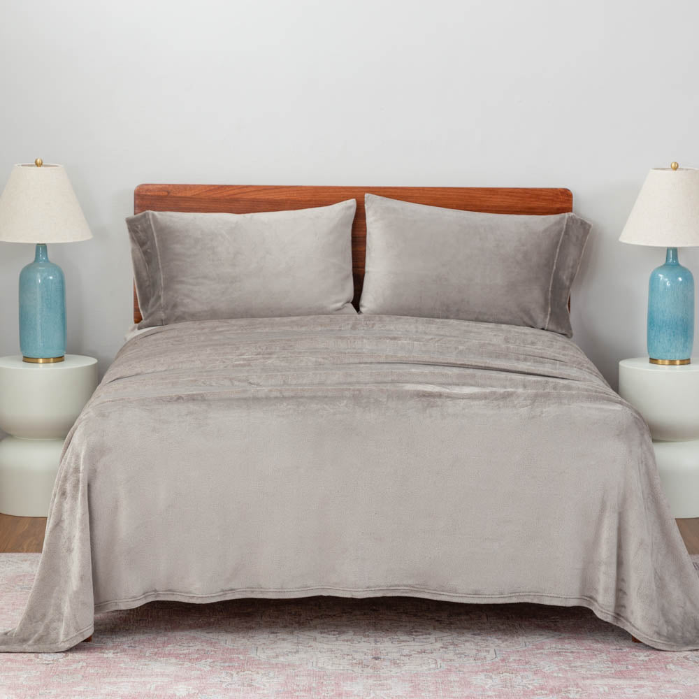 wild dove (gray) sheet set on a large bed with two lamps on either side.