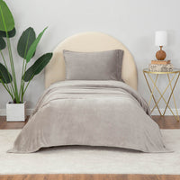 Wild Dove  (gray) sheet set styled with neutral decor accent, plant on one side and nightstand on other side.