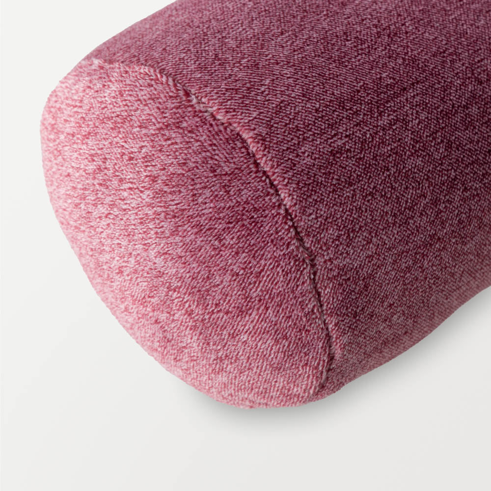 A close up of a pink EcoThread Neckroll Pillow, displaying its soft and plush texture.