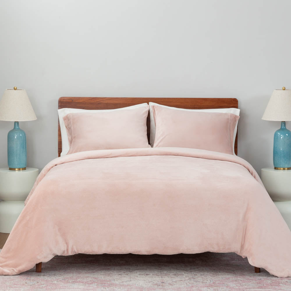 A bed made with the rose smoke green VelvetLoft® Plush Duvet Cover Set, creating a cozy and inviting look.