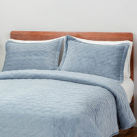 A bed styled with the Polar Blue VelvetLoft® Quilt Set, paired with two pillow shams.