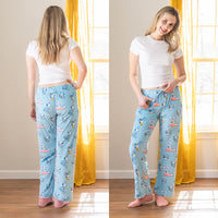 A woman wearing blue Peanuts printed lounge pants while tanding in a living room.