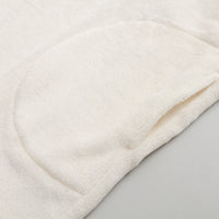 Close up of the pocket of our Peanuts social club embroidered lounge hoodie on a white surface.