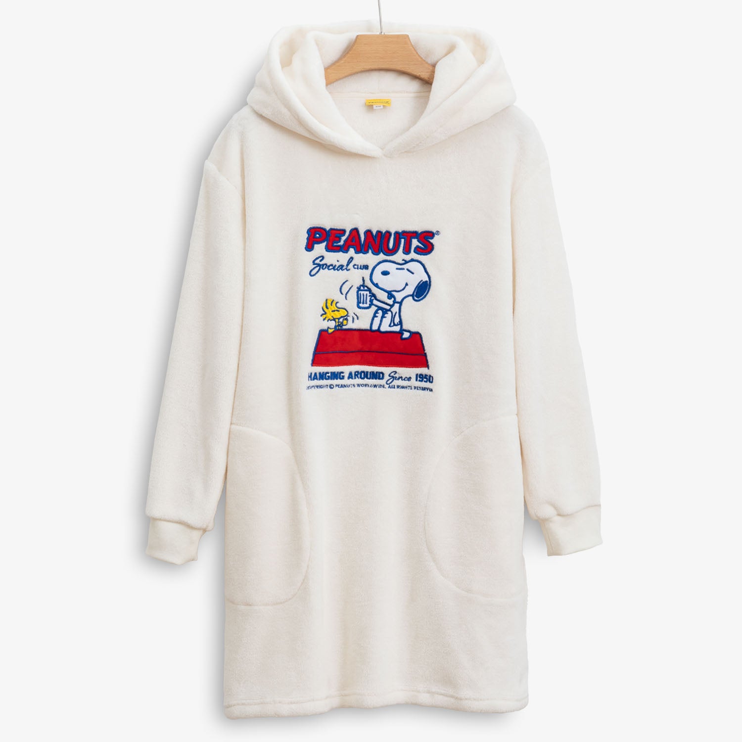 Peanuts social club embroidered lounge hoodie hung on a hanger on a white surface.