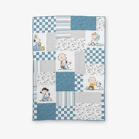 Peanuts patchwork quilt set laid flat on a white surface.