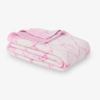 Pink and white tie-dye blanket on a white background
