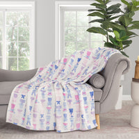Cocktail and bows printed velvetloft throw draped neatly over a grey chair.