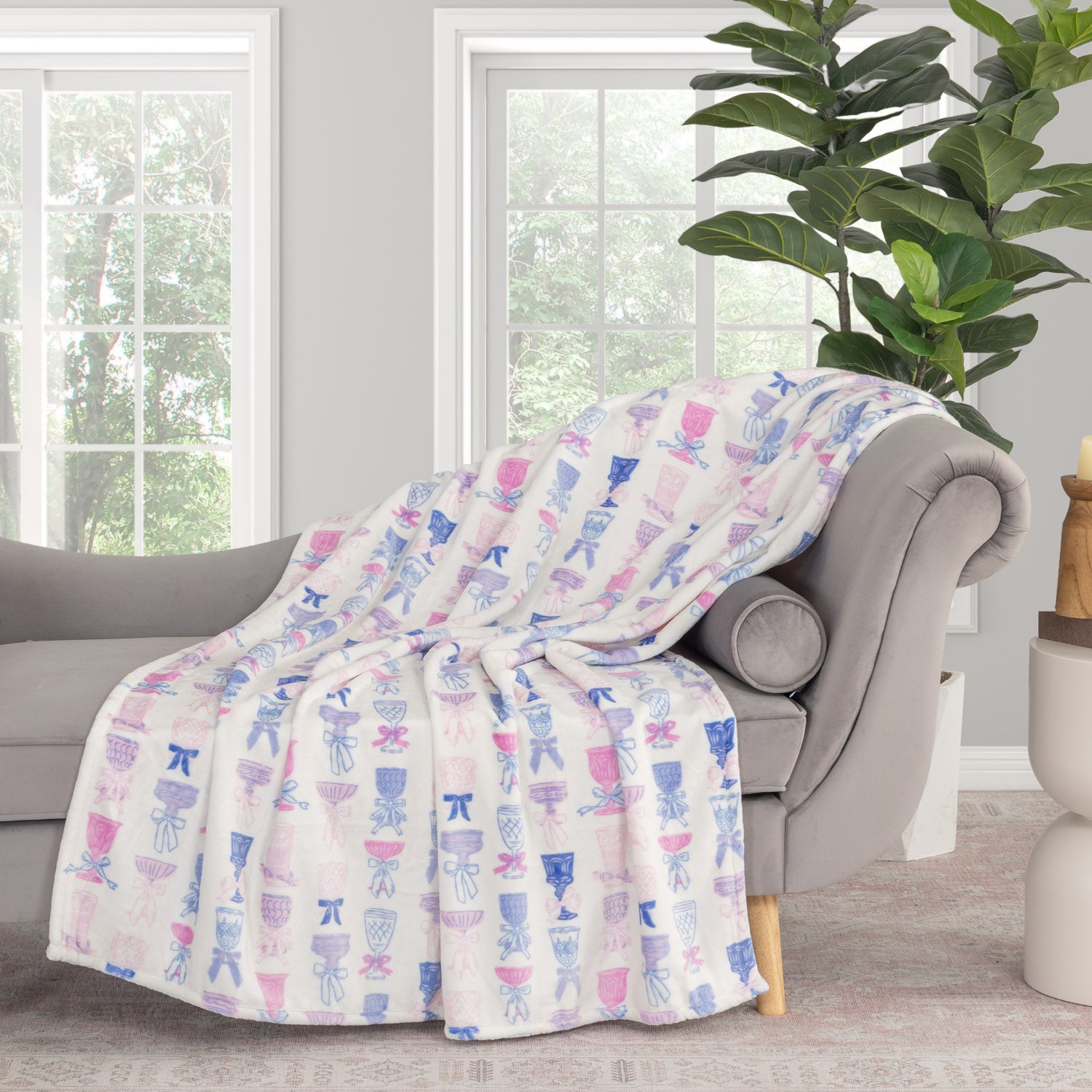Cocktail and bows printed velvetloft throw draped neatly over a grey chair.