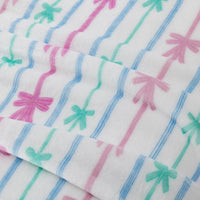 Close-up of fabric with colorful bow pattern on a white background