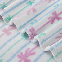 Close-up of a soft fabric with pink and blue  and green bow patterns on a white blanket
