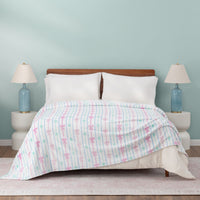 Bed with a Bow Print blanket in a bedroom setting with lamps on either side.