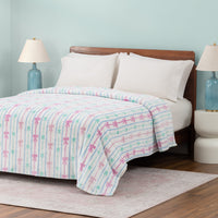 Bed with a colorful striped blanket in a bedroom setting