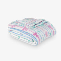 Folded blanket with colorful bow stripe pattern on a white background
