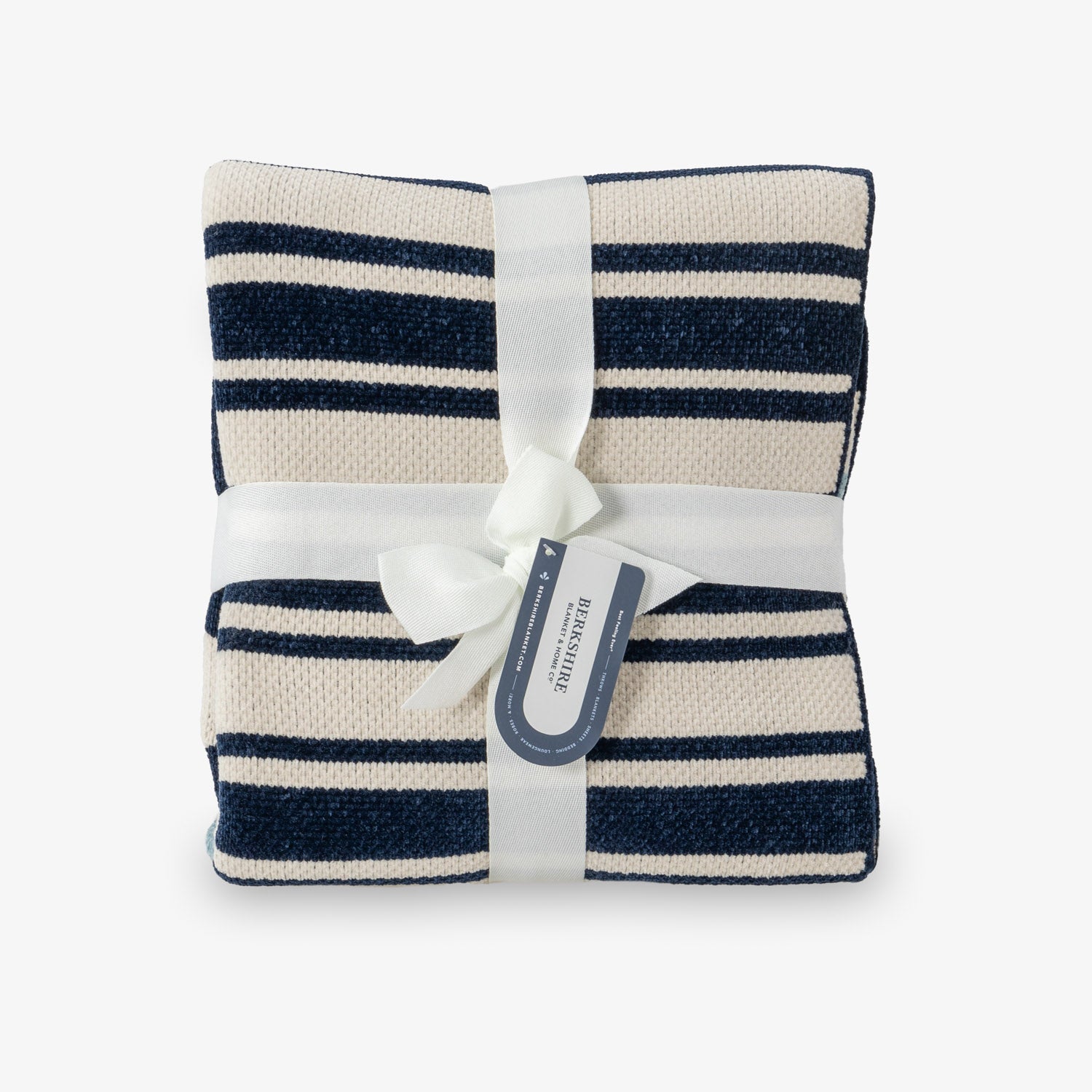 Navy and white striped blanket with a white ribbon and tag on a light gray background