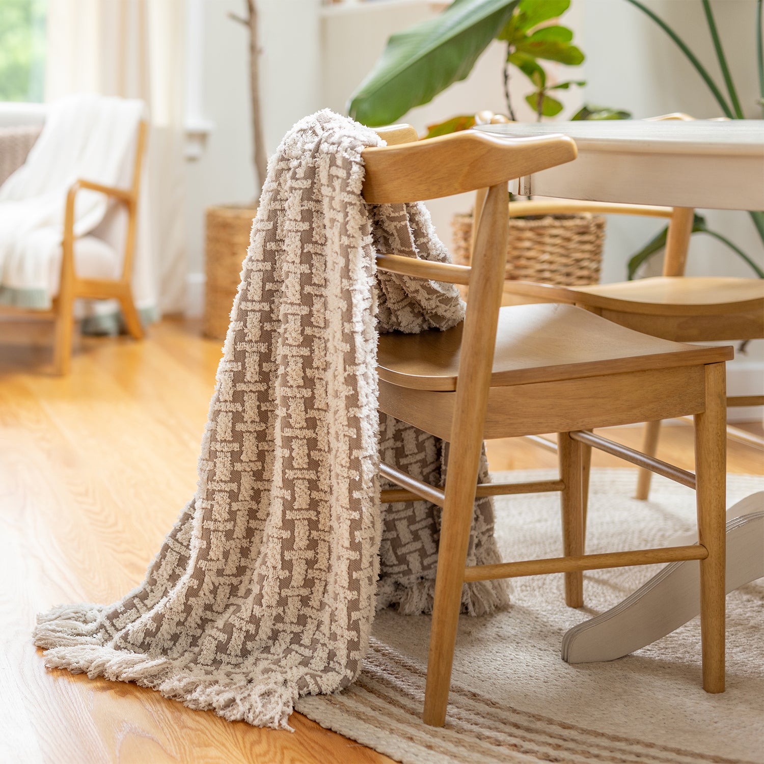 Textured blanket draped over a wooden chair in a cozy living room setting.