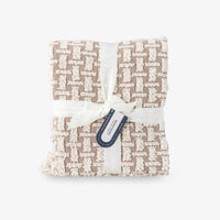 Folded fabric with a geometric pattern and a visible tag on a white background