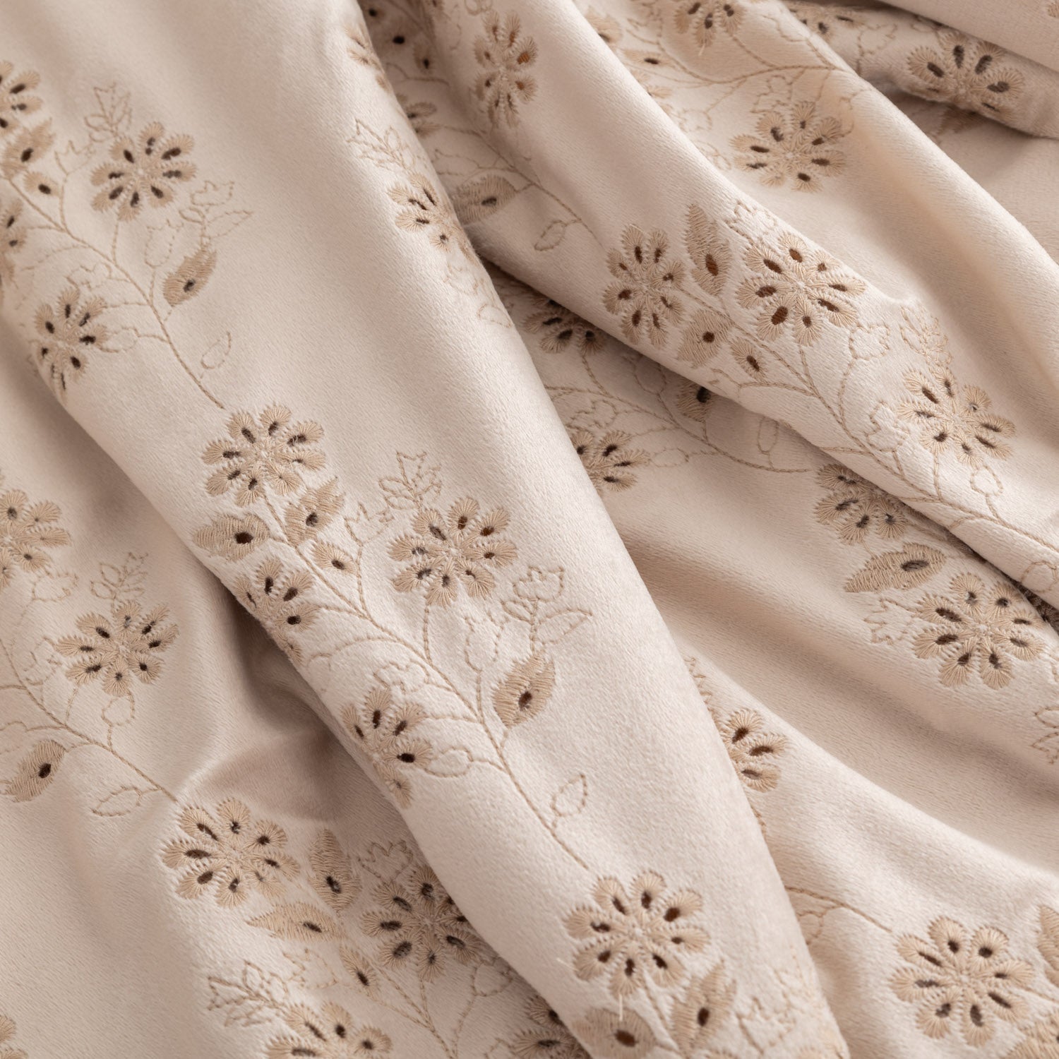 Close up of a tan eyelet ruffle throw.