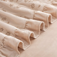 Close up of a tan eyelet ruffle throw.