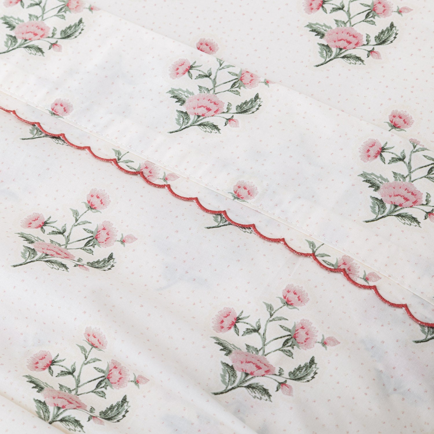Floral patterned fabric with pink flowers and green leaves on a white background