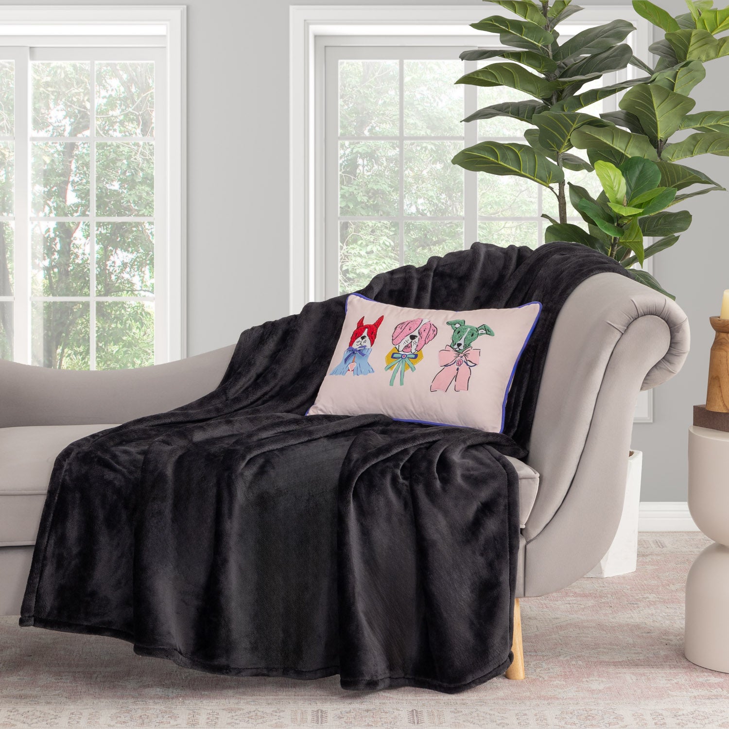 Krissy Mast dog printed pillow sitting on a black throw draped over a grey chair.