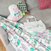 Pickleball dogs set including a pillow, a bag, and pickleball toys on a couch.