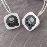 Two digital thermometers on a grey blanket surface